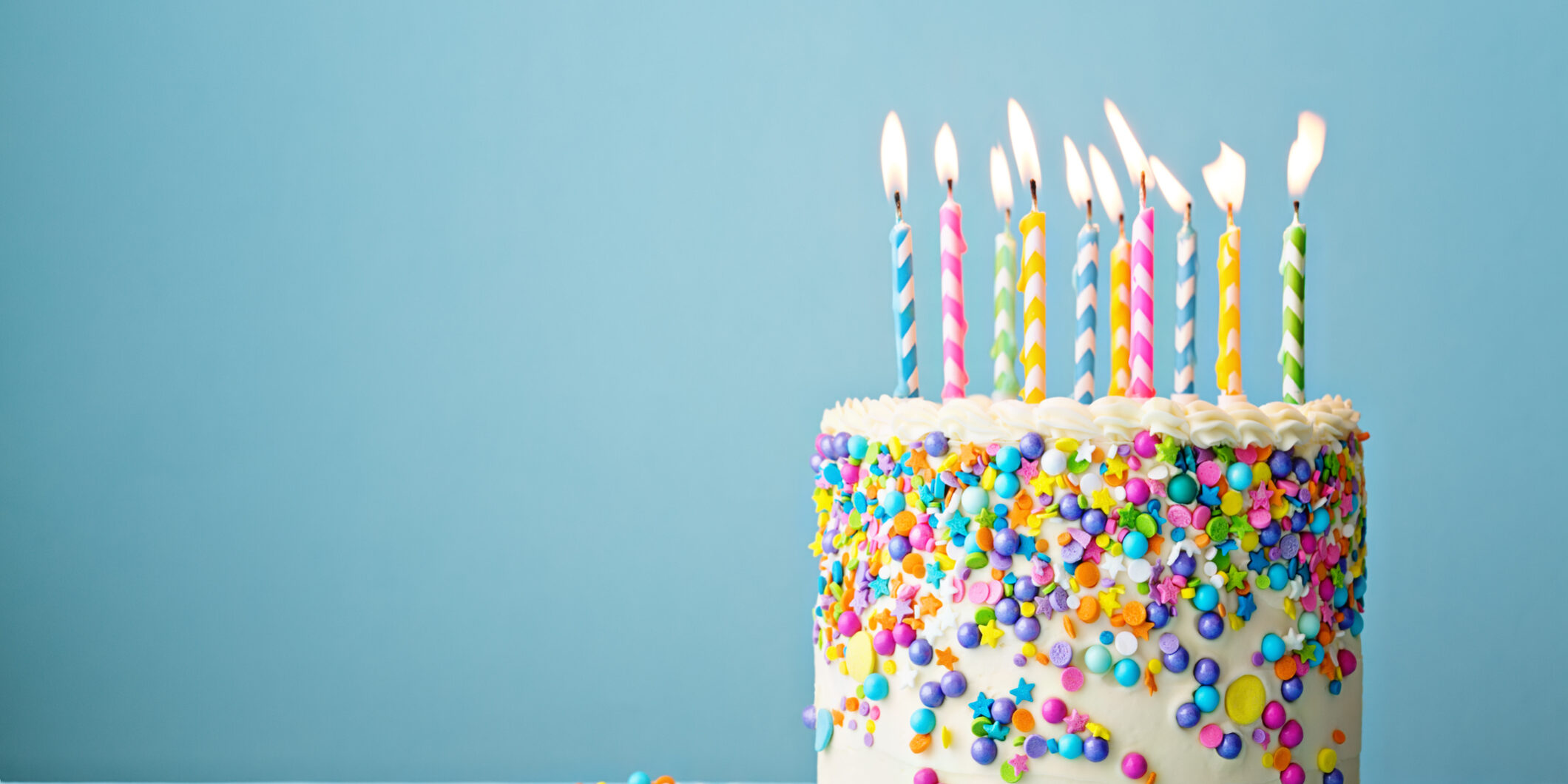 Birthday cake decorated with colorful sprinkles and ten candles