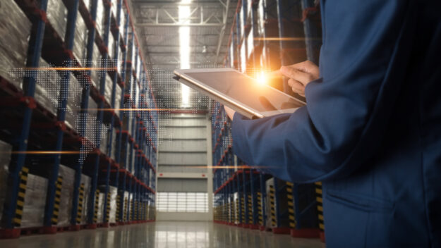 Factory worker using application on smart tablet to operate automation for modern trade. Import and export the shipping cargo of global logistic.