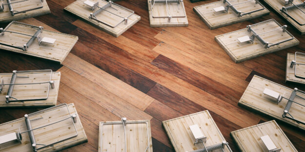 Empty mouse traps on wooden floor, copy space. 3d illustration