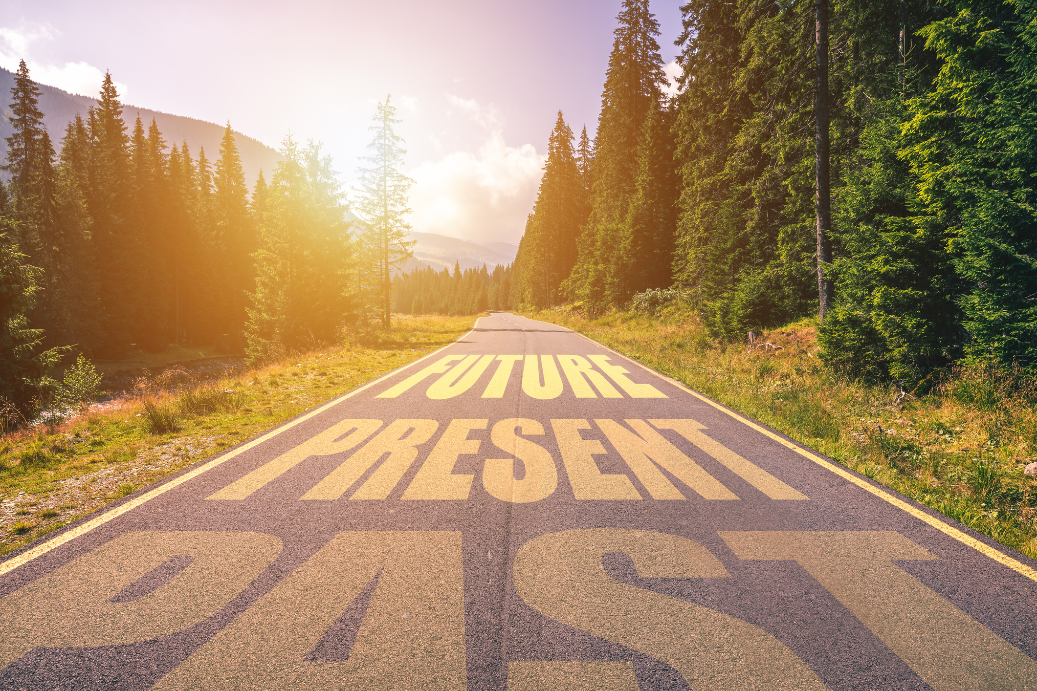 Past, Present, Future concept. Driving on an empty road in the mountains to the Future passing Present and leaving behind the Past.